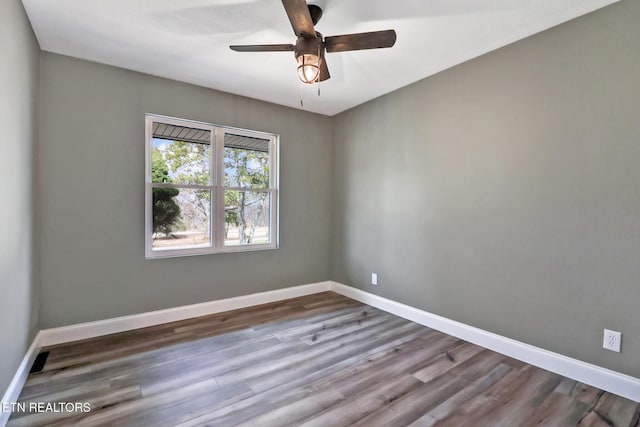 unfurnished room featuring ceiling fan, wood finished floors, and baseboards