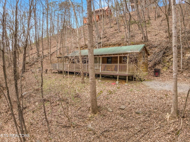 back of property with covered porch and metal roof