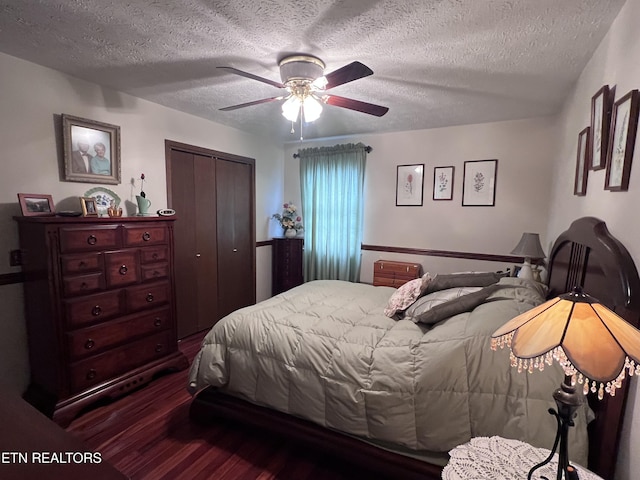 bedroom featuring dark wood-style floors, ceiling fan, a textured ceiling, and a closet