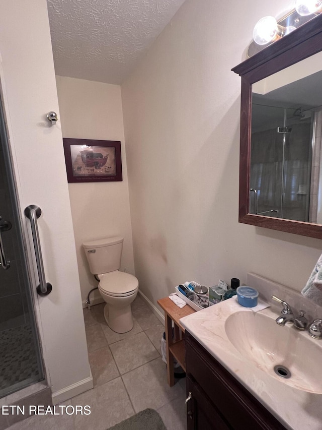 full bathroom with a textured ceiling, toilet, vanity, a shower stall, and tile patterned floors