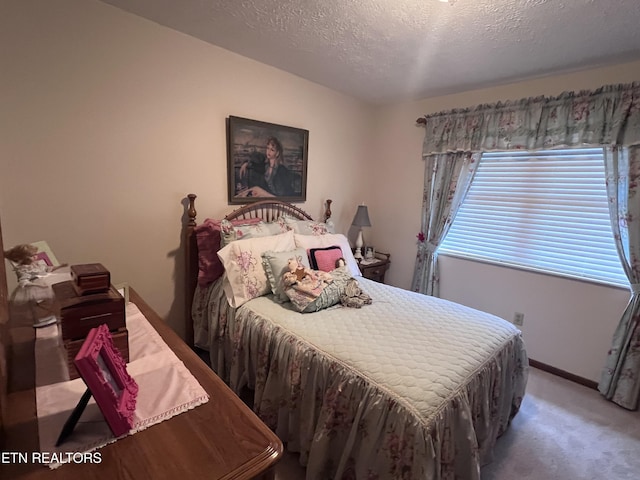 carpeted bedroom featuring a textured ceiling and baseboards