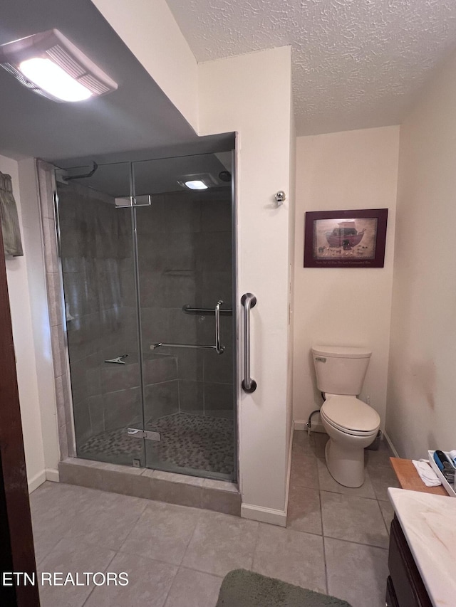 full bath with a stall shower, toilet, tile patterned flooring, a textured ceiling, and vanity