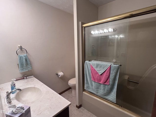 bathroom featuring toilet, vanity, a textured ceiling, tile patterned flooring, and baseboards