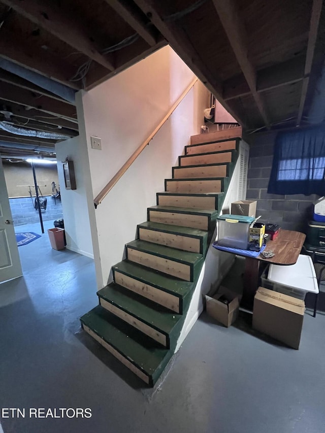 interior space with finished concrete floors and concrete block wall