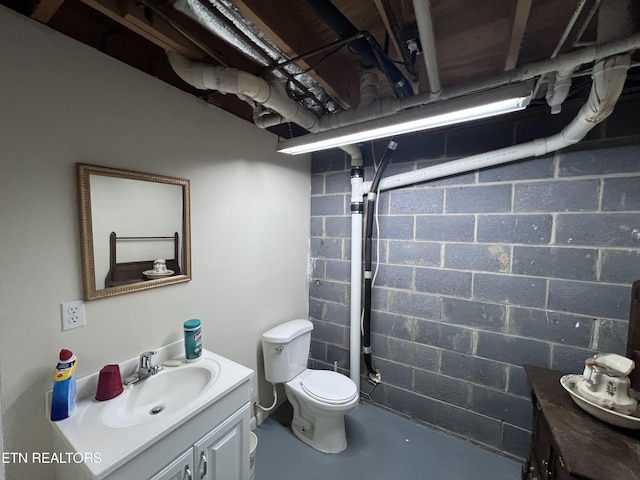 bathroom featuring toilet, concrete floors, and vanity