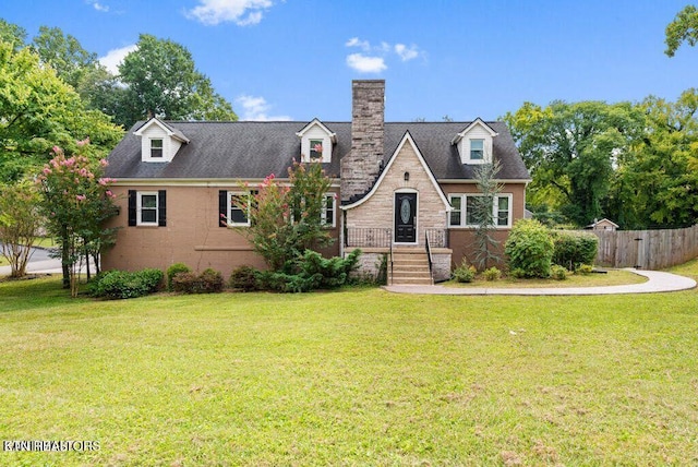 back of house featuring a yard, brick siding, and fence