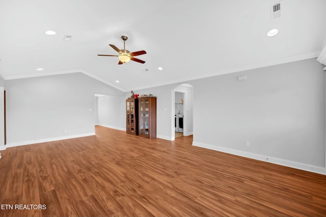 unfurnished living room with arched walkways, ceiling fan, ornamental molding, wood finished floors, and vaulted ceiling