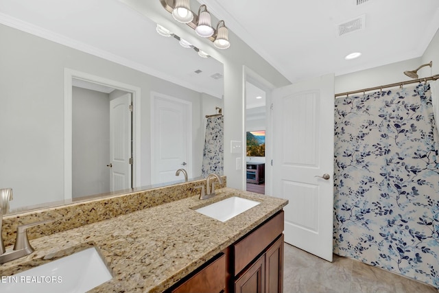 bathroom featuring visible vents, a sink, and ornamental molding