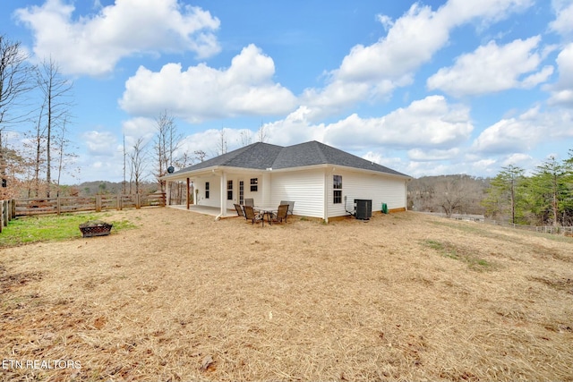 back of house with a shingled roof, central air condition unit, fence, and a patio