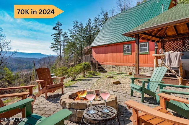 view of patio with a fire pit, a gazebo, stairs, and a mountain view