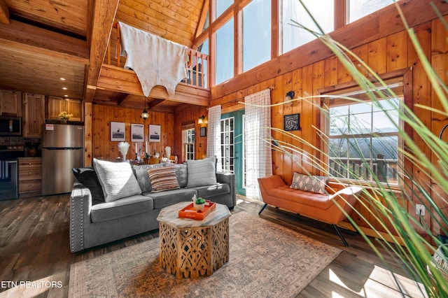 living room with wooden walls, a towering ceiling, wood ceiling, dark wood-style flooring, and beam ceiling