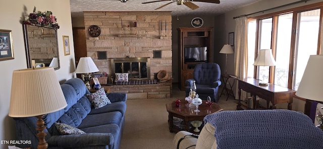 carpeted living area with ceiling fan, a fireplace, and a textured ceiling