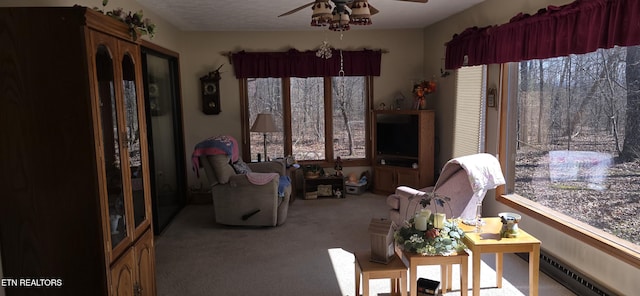 sitting room featuring carpet floors, a baseboard radiator, and a ceiling fan