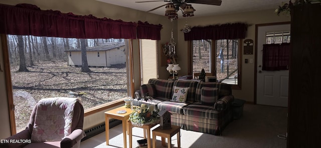 living room with a ceiling fan, a baseboard heating unit, and carpet floors