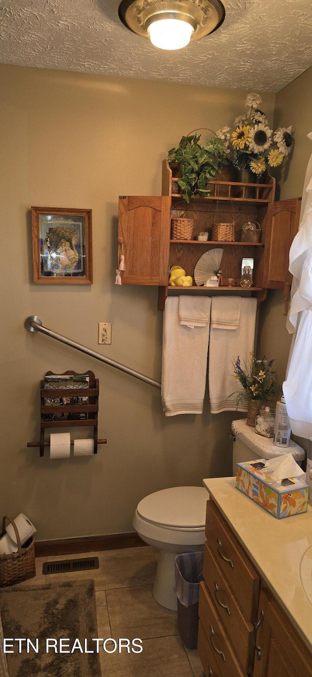 bathroom with visible vents, toilet, wood finished floors, a textured ceiling, and vanity