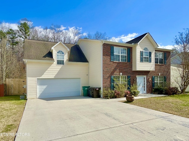 view of front of property featuring brick siding, concrete driveway, a front yard, and fence