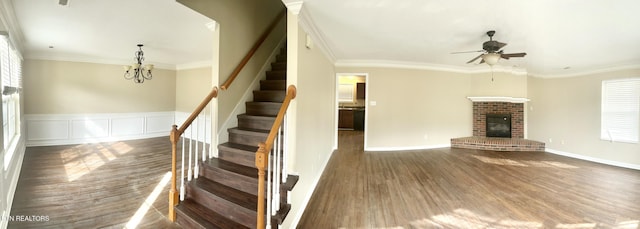 interior space featuring wood finished floors, ornamental molding, and a fireplace