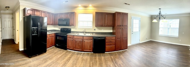 kitchen featuring wood finished floors, baseboards, visible vents, a sink, and black appliances