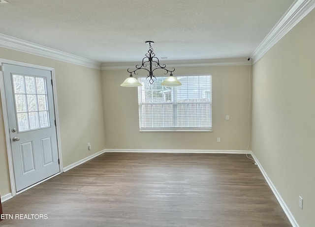 unfurnished dining area with crown molding, baseboards, dark wood-type flooring, and a chandelier