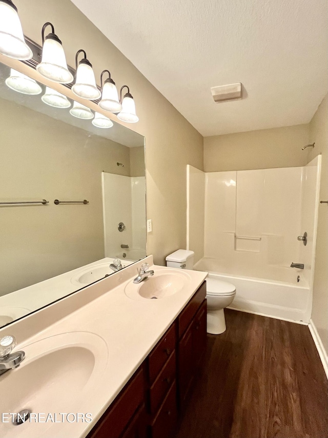 full bathroom featuring toilet, wood finished floors, and a sink