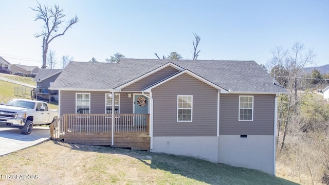 view of front of property featuring a shingled roof, a front yard, and a porch