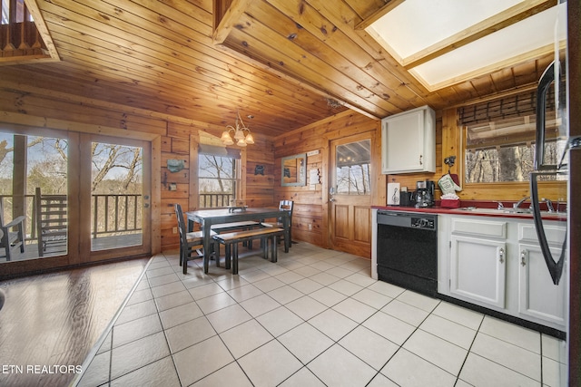 kitchen featuring wood walls, wood ceiling, black dishwasher, a notable chandelier, and white cabinetry