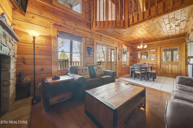 living area with a healthy amount of sunlight, wooden ceiling, wood walls, and hardwood / wood-style flooring