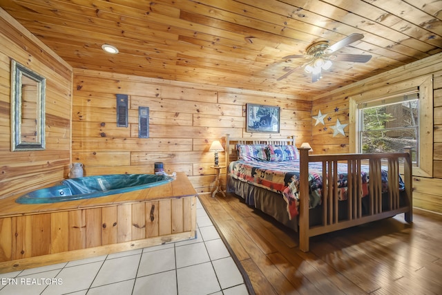 tiled bedroom featuring wood ceiling, ceiling fan, and wood walls