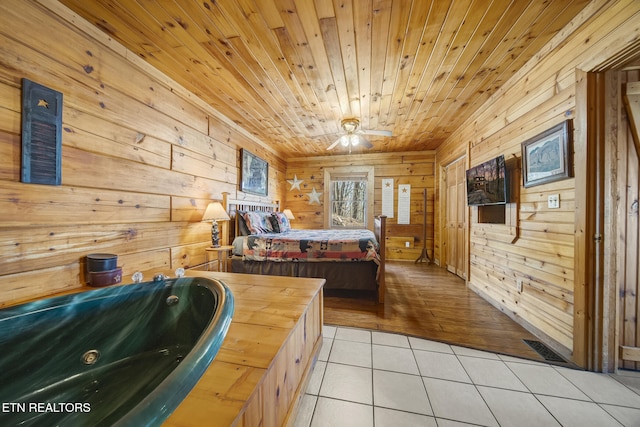 bedroom with light tile patterned floors, wood ceiling, visible vents, and wood walls