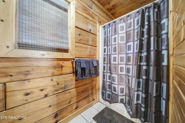 bathroom with a shower with shower curtain, wood walls, wooden ceiling, and tile patterned flooring