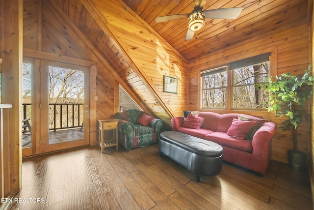 living area with wooden walls, wooden ceiling, hardwood / wood-style flooring, and vaulted ceiling