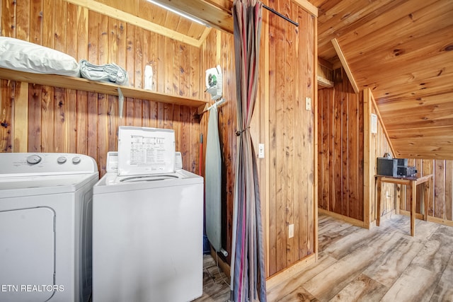 laundry room with wood finished floors, laundry area, wood walls, wooden ceiling, and washing machine and dryer