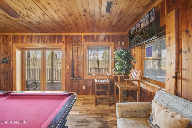 playroom with visible vents, wood finished floors, wood walls, and wooden ceiling