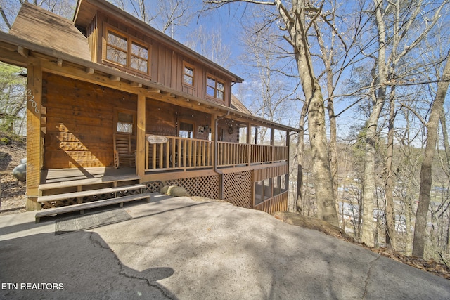 exterior space with log siding, covered porch, and board and batten siding