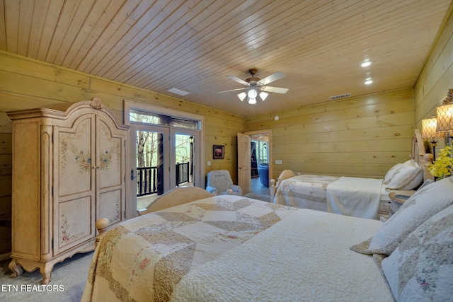 bedroom featuring wooden walls, visible vents, light colored carpet, wood ceiling, and access to outside