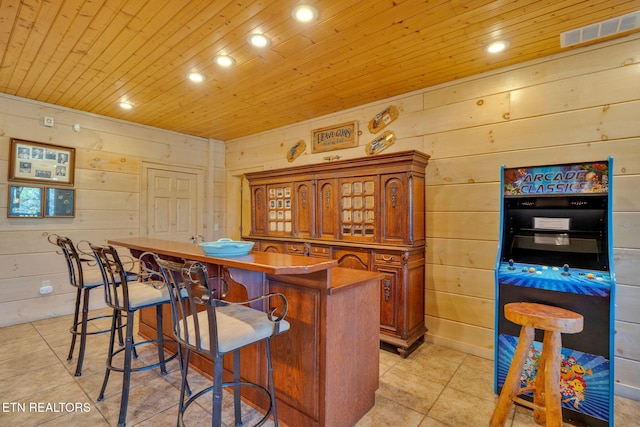 kitchen featuring wooden ceiling, a kitchen bar, visible vents, and brown cabinets