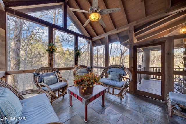 sunroom / solarium with lofted ceiling with beams, ceiling fan, and wooden ceiling