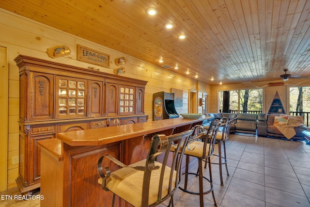 kitchen featuring wooden ceiling, a kitchen bar, glass insert cabinets, and brown cabinets