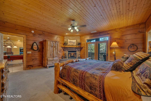 bedroom featuring access to outside, carpet flooring, wood ceiling, and wooden walls