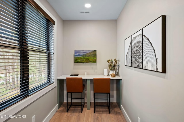 office with visible vents, baseboards, and light wood-style flooring