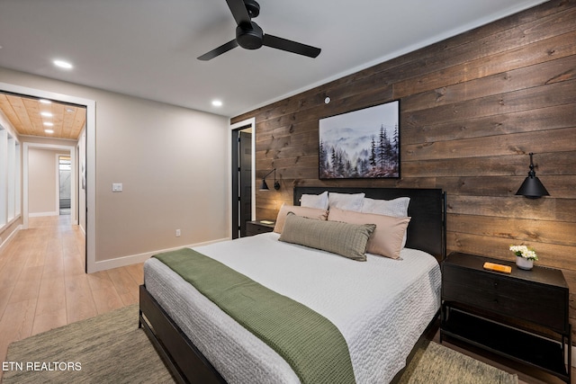 bedroom with wooden walls, ceiling fan, baseboards, recessed lighting, and wood finished floors