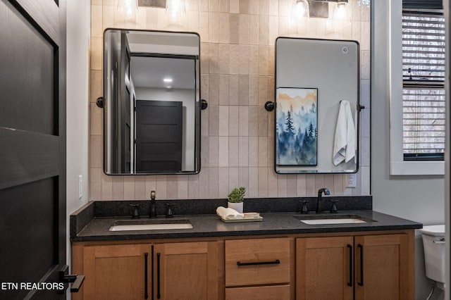 bathroom featuring a sink, toilet, and double vanity