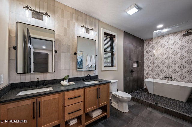 bathroom with a sink, toilet, tile walls, and tile patterned floors