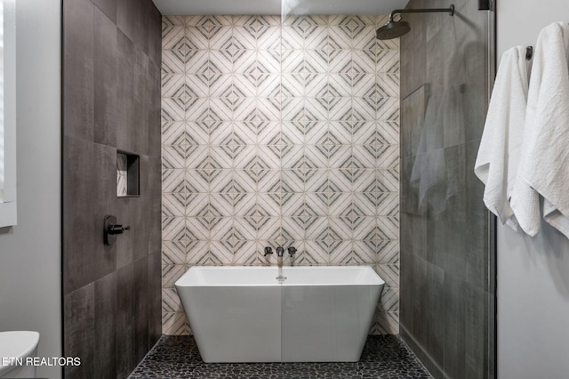 full bathroom featuring tile patterned flooring, tile walls, a freestanding tub, and tiled shower