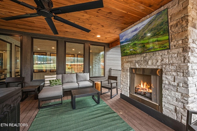 wooden terrace with an outdoor living space with a fireplace and ceiling fan