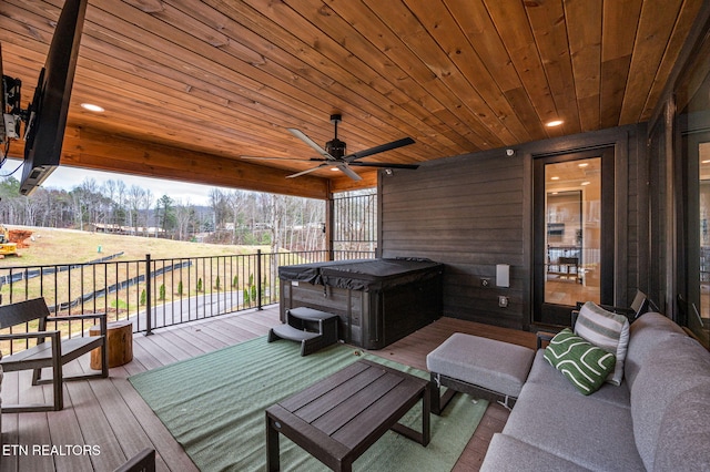 wooden deck with an outdoor living space, a hot tub, and ceiling fan