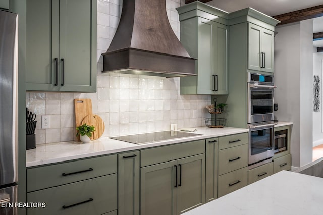 kitchen with decorative backsplash, custom exhaust hood, appliances with stainless steel finishes, and green cabinetry