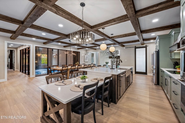 kitchen with light wood-type flooring, light countertops, green cabinets, and a barn door