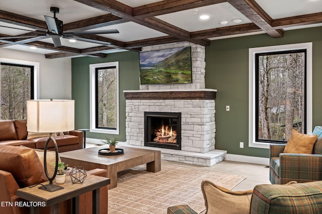 living area with baseboards, beam ceiling, a fireplace, wood finished floors, and coffered ceiling