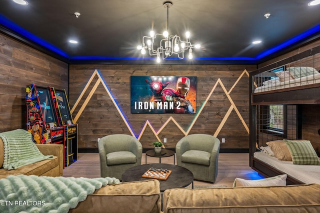 home theater featuring a chandelier, wooden walls, and wood finished floors